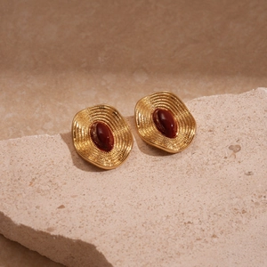 Détails de boucles d'oreilles vintage en or avec pierres précieuses rouges sur pierre