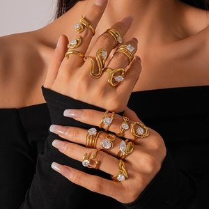 Detail of stacked irregular gold rings with white zircon stones on model hand