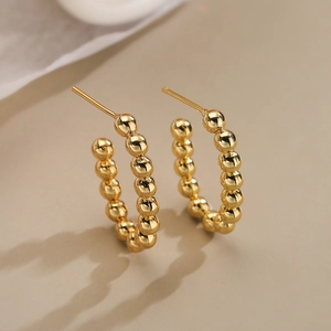 Polished 18K gold plated beaded C-shaped hoop earrings for women in a luxury aesthetic