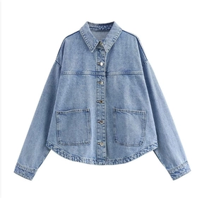 Giacca di jeans azzurra distesa con tasche a patta e dettaglio sull'orlo curvo