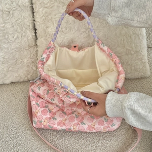 Top view of the pink floral quilted bag interior with inner pocket and metal snap closure