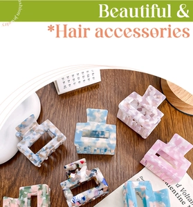 Close-up of assorted square acetic acid hair claws in pastel colors on wooden surface