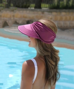 Outdoor sun visor for women in wine red with wide brim and elastic back strap in a pool setting