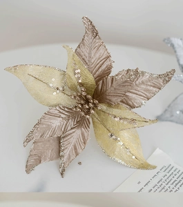 Gros plan d'un poinsettia de Noël champagne et or avec paillettes sur marbre blanc