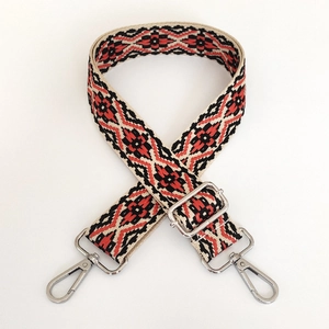 Close-up of 3.8cm red and black ethnic jacquard bag strap with silver metal swivel hooks