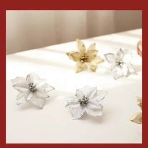 Detail of 13cm sparkling silver and gold artificial poinsettia flowers with glitter petals