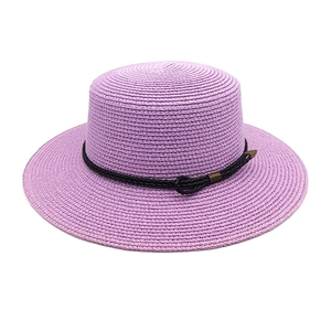 Detail of lavender straw sun hat showing fine weave texture and gold buckle trim