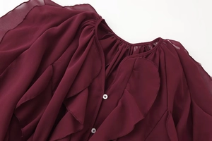 Detail of burgundy chiffon blouse showing layered ruffles and white buttons on neckline