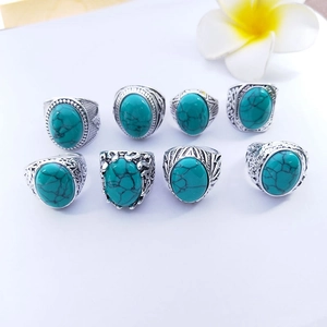 Detail view of eight retro men's alloy rings with turquoise stones and floral decor