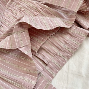 Detail of pink and white striped canvas bag with high-quality embroidery and stitching