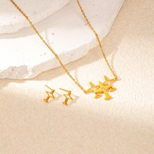 Detailed macro view of gold star and airplane jewelry set on a natural stone base