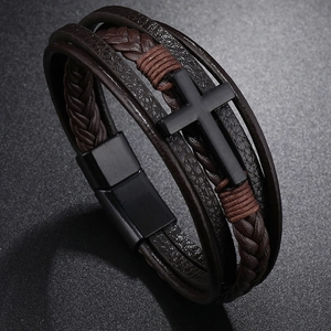 Detail view of multi-layer brown leather bracelet with black metal cross and magnetic clasp