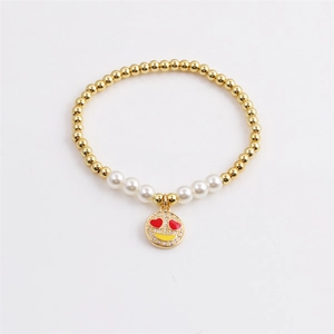 Gold beaded pearl bracelet with a sparkling red heart-eye smiley face charm for women