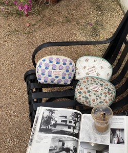 Detailed outdoor shot of quilted cotton makeup bags with floral and cherry patterns