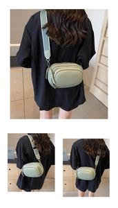 Detail of light green camera bag with lychee texture and wide fabric strap