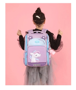 Purple unicorn school bag with ergonomic straps shown on a young girl model back