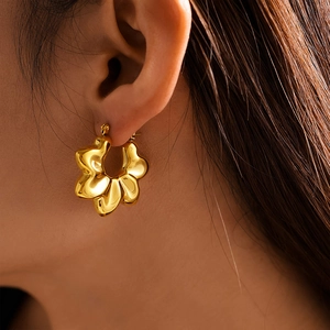 18K gold plated hollow wavy flower stud earrings shown on model for women