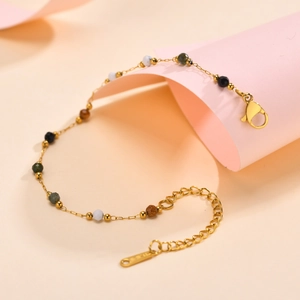 Detail of gold beaded bracelet featuring multi-color stones and adjustable lobster clasp