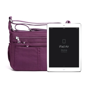 Bolso bandolera grande de nailon morado con múltiples bolsillos junto a un iPad para escala