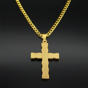 Detailed view of golden stainless steel cross pendant with brushed finish on Cuban chain