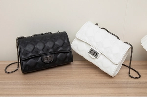 Detail of black diamond quilt and white heart pattern PU bags with metal chains