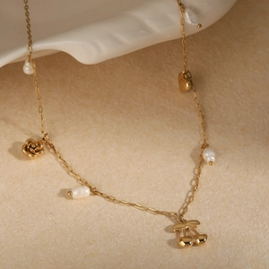 Collier élégant en acier doré avec perles blanches, pendentifs fleur et cerise