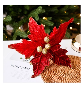 Détail de poinsettia en velours rouge avec bordures dorées sur fond de Noël festif