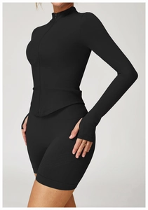 Détail de la veste de yoga noire en maille côtelée avec col montant et passe-pouces
