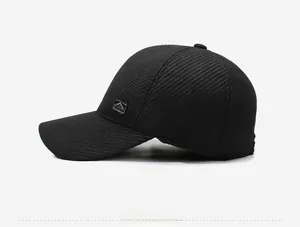Side view of black winter baseball cap with mountain logo metal plate and twill texture