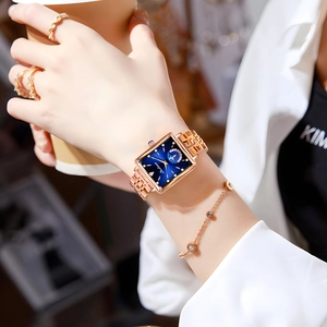 Detail of luxury square gold watch with deep blue dial and matching gold bracelets