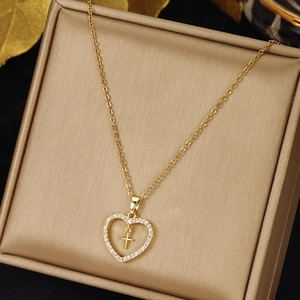 Detailed close-up of a heart and cross pendant necklace with sparkling white zircons