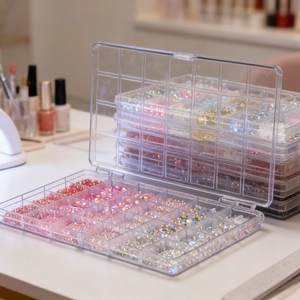 Detail of 24-grid organizer box filled with colorful rhinestones and nail art pearls