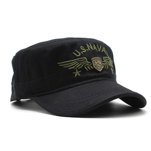 Detail view of black military patrol cap with U.S. NAVY embroidery and metal shield badge