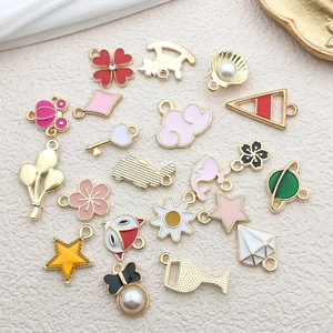 Flat lay of colorful enamel charms in flower, star, and cloud shapes for DIY jewelry making