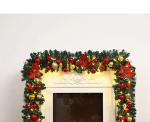 Close-up of 2.7m Christmas garland with red gold ornaments and LED lights on a white fireplace
