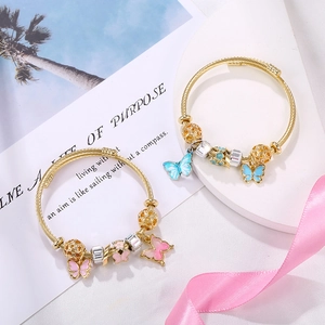 Golden open cable bracelet with pink and blue enamel butterfly pendants and beads