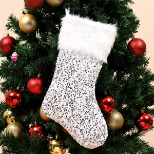 Calza di Natale con paillettes argento e bordo in peluche bianco appesa a un albero festivo