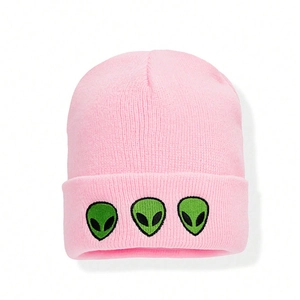 Pink knitted beanie hat featuring green alien embroidery with a stylish folded cuff design