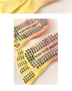 Detailed macro view of yellow pink gradient yoga toe socks with heart silicone grips