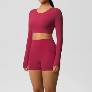 Details van een dieprood yogasetje met high-waist shorts, zijzakken en een crop top-top