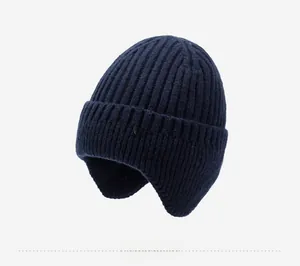 Detail view of the navy blue ribbed knit texture and metallic logo on the winter earflap hat