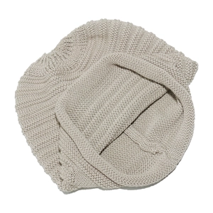 Close-up of beige knitted slouchy beanie showing thick warm wool texture for winter