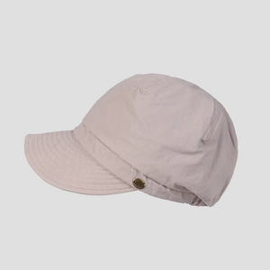 Detailed side view of beige cotton newsboy cap with vintage metal button and twill texture
