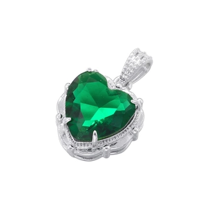 Macro shot of a luxury heart pendant featuring a faceted green gemstone in silver setting