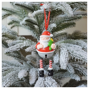 Festive Santa Claus bell ornament hanging on a snowy Christmas tree branch