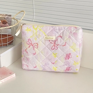 Macro detail of quilted cotton makeup bag with floral patterns and sturdy metal zipper