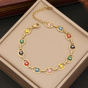 Gold chain bracelet with colorful heart-shaped evil eye enamel charms on jewelry box