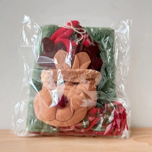 Close-up of a festive plush reindeer chair cover in protective transparent plastic packaging