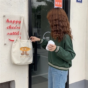 Sac cabas beige en velours côtelé avec broderie présenté dans une scène de rue décontractée