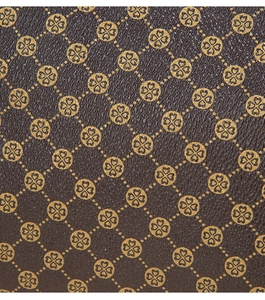 Macro di pelle marrone martellata con motivo monogramma floreale dorato di classe